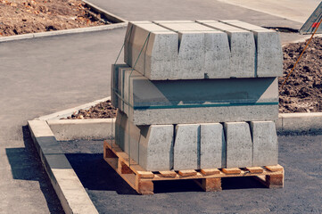 Curb stone on construction site. Pallet With A Stack Of Concrete Curbstone. Road repairs.
