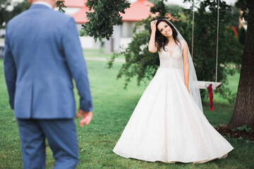 Obraz na płótnie Canvas Beautiful luxury young bride in wedding dress posing in park