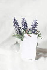 Business card mockup with lavender flowers on white background.