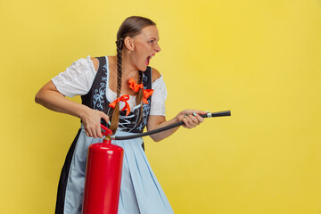 Comic portrait of beautiful Oktoberfest woman, waitress wearing a traditional Bavarian or german dirndl isolated on yellow studio background.