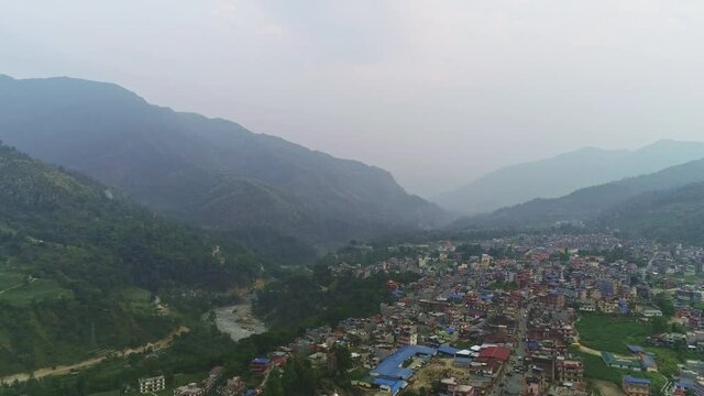 Misty aerial panorama above green Marshyangdi river valley with Besisahar town besides, Nepal 