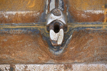 A rusty metal structure on the shovel of an excavator.