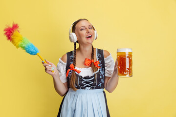 Comic portrait of beautiful Oktoberfest woman, waitress wearing a traditional Bavarian or german dirndl isolated on yellow studio background.