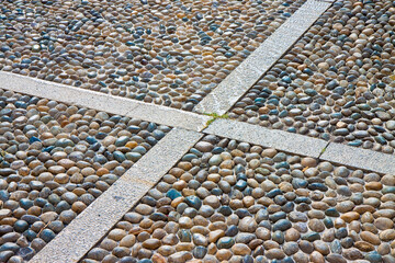 Detail of a coloful rounded pebble floor, permeable to water, with polished stone in a italian...