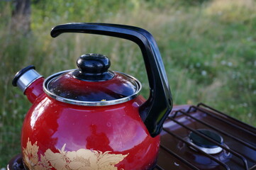 a teapot on a gas stove in a field, on a tourist trip