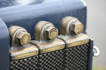 The side view of an old farming tractor on a farmers fair in Mühlengeez-Germany. A brass colored cooler.