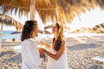 Happy beautiful latino couple spending time together on the tropical beach. Boho wedding. Real...