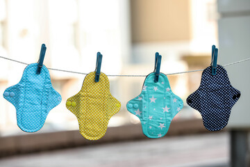 Many different menstrual cloth pads hanging on rope outdoors