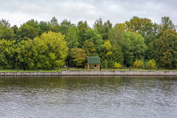 Naklejka premium Scenic river landscape with green trees in early autumn