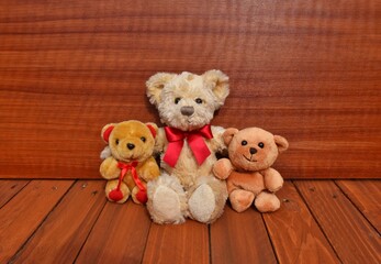 Obraz premium teddy bear with red ribbons. Wooden background 