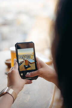 Unrecognizable woman taking photo of beer and snacks on smartphone