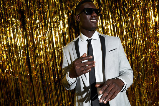 Stylish black man in sunglasses dancing during party