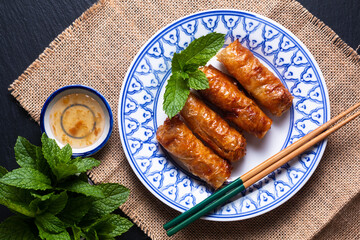 Food concept Vietnamese fried Rice paper spring rolls with mints on black background with copy space