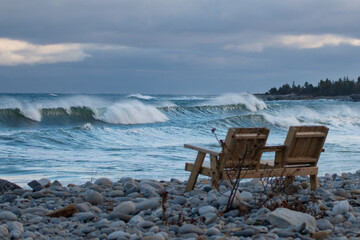 Fototapeta na wymiar bench on a beach large waves