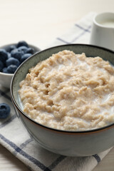 Tasty oatmeal porridge served on table, closeup