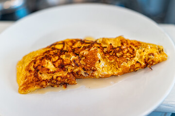 Fresh hot cheese egg omelette on white plate cooked burnt overcooked for morning traditional breakfast closeup