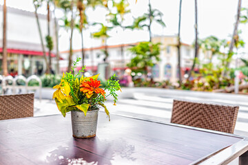 Miami Beach at South Beach city with closeup of outdoor cafe restaurant food table and flowers in vase and background of Lincoln Road street