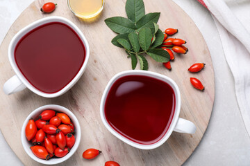 Fresh rose hip tea and berries on light table, flat lay