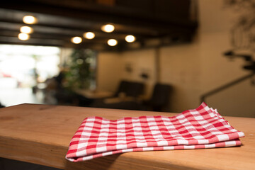 Napkin and board for pizza on wooden desk. Stack of colorful dish towels on white wooden table...