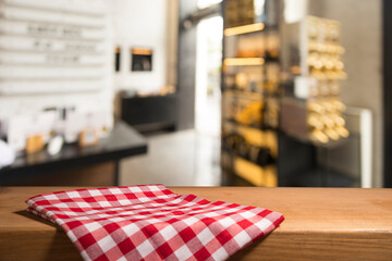 Napkin and board for pizza on wooden desk. Stack of colorful dish towels on white wooden table...