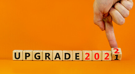 Symbol of planning 2022 upgrade new year. Businessman turns a wooden cube and changes words...