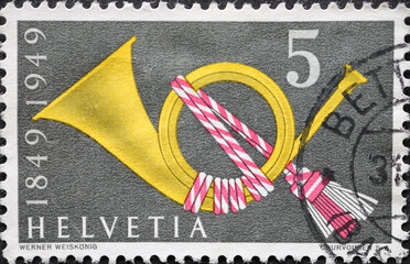 Switzerland - Circa 1949: a postage stamp printed in the Switzerland showing a historic post horn....