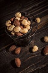 Tiny bucket of assorted nuts on a wooden background
