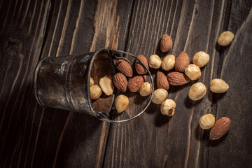 Tiny bucket of assorted nuts on a wooden background