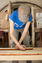 Female hands are making some marks on wooden plank for future holes using pencil for assembling...