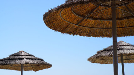 beach straw umbrellas from the sun on the background of the blue sky sea resort vacation summer vacation sun