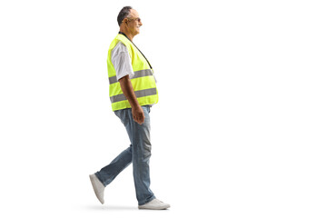Full length profile shot of a mature man in a safety vest walking
