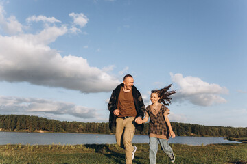 Father and daughter share love, have fun in park. Family outdoor vacation together. Happy Father's Day!