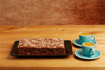 Homemade chocolate cake and two cups of coffee espresso on wooden table. Shallow focus.