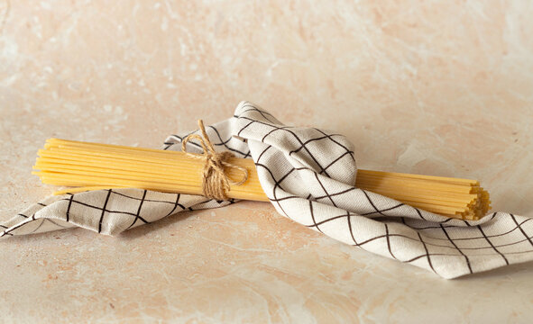 the raw spaghetti is wrapped in a checkered towel