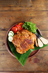 Ayam bakar Taliwang  is a traditional roast chicken from Lombok Indonesia on a wooden background.
