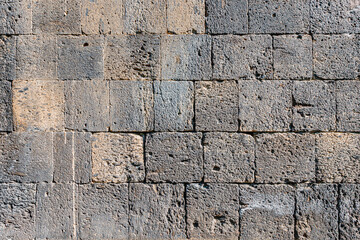 Background and texture of a grey stone masonry in the wall of an ancient church or house. Old and speckled sandstone