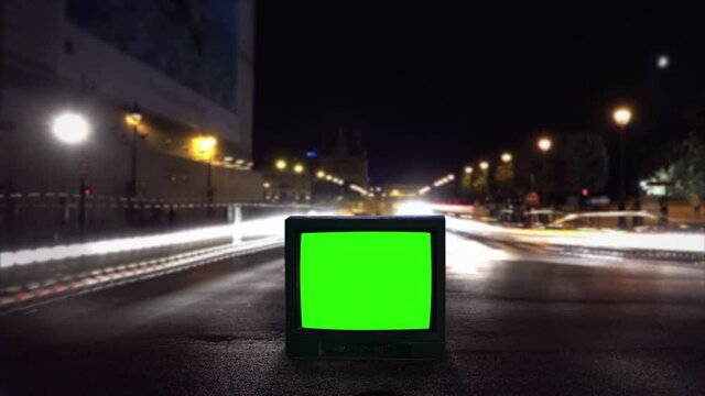 TV Green Screen On Street Night Traffic, Time Lapse Old Television. Old green screen TV on the street at night. Time lapse of cars and an amusement park in the background