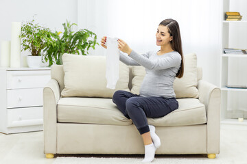 Obraz premium Photo of pregnant woman holding child small clothes.