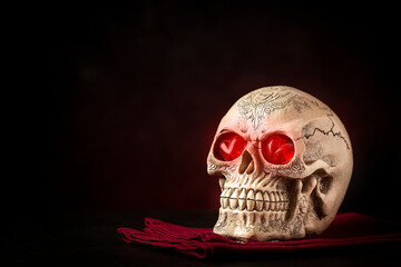Halloween catrine skull on an black table in dark background.