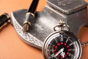 Fountain pen, beautiful details of a beautiful fountain pen, an antique ink holder and a beautiful pocket watch placed on caramel leather, selective focus.