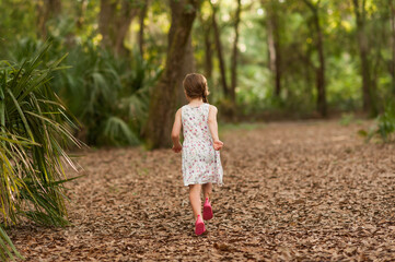 Family playing frisbee in the forest walking in wilderness nature