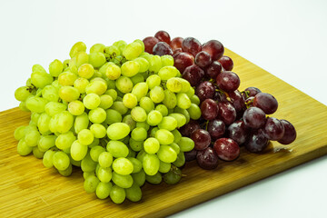 Bunch of red and green fresh grapes on wood and white bacground