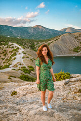 A beautiful young woman in a dress on Cape Kapchik in the Crimea. Romantic seascape