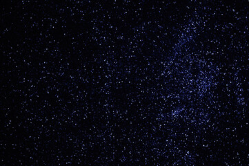 Blue stars in space, sky, defocused blue lights, shiny particles, abstract background