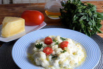 delicious gnocchi pasta in white sauce with parmesan cheese, tomato, basil, herbs, healthy food from Italian and French cuisine