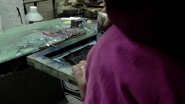 Printing Process in the Manufacturing of Soccer Balls: Female Worker Using Screen Printing Squeegee. Close Up. 
