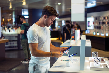 Young man buying gadget in store