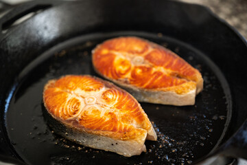 grilling salmon fillet steak on iron skillet pan