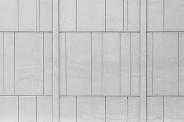 The exterior wall of the cement building is painted white with a line pattern texture and...