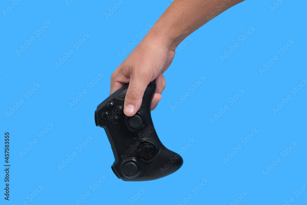 Wall mural gamepad in man hand on blue background, game joystick, computer games and entertainment.